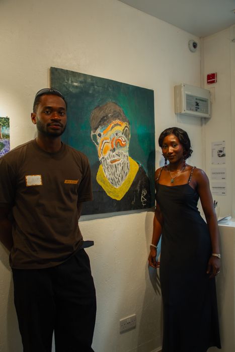Guests standing beside their paintings